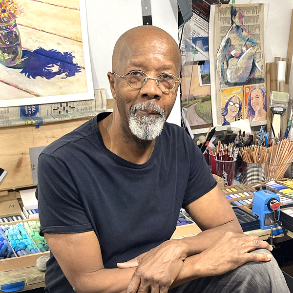 Clarence porter sitting in his studio surrounded by his paintings