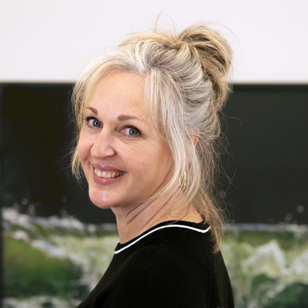 Jessica Masters smiling with a pastel of a wave in the background